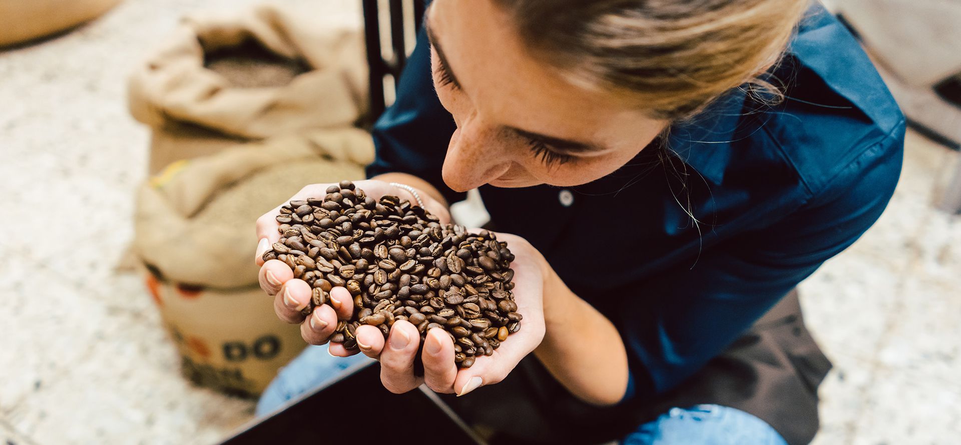 Woman with coffee beans in the hand.