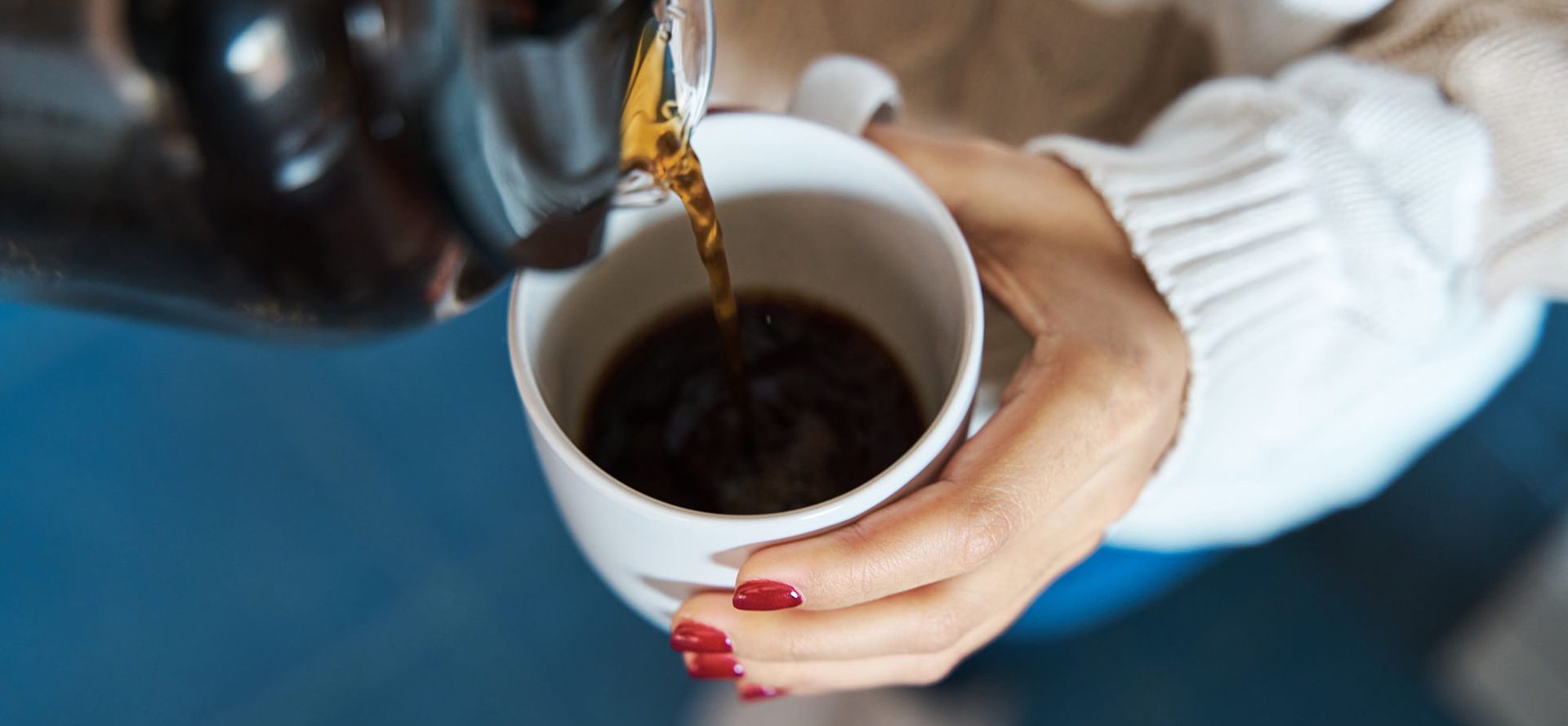 A cup of coffee in female hand.