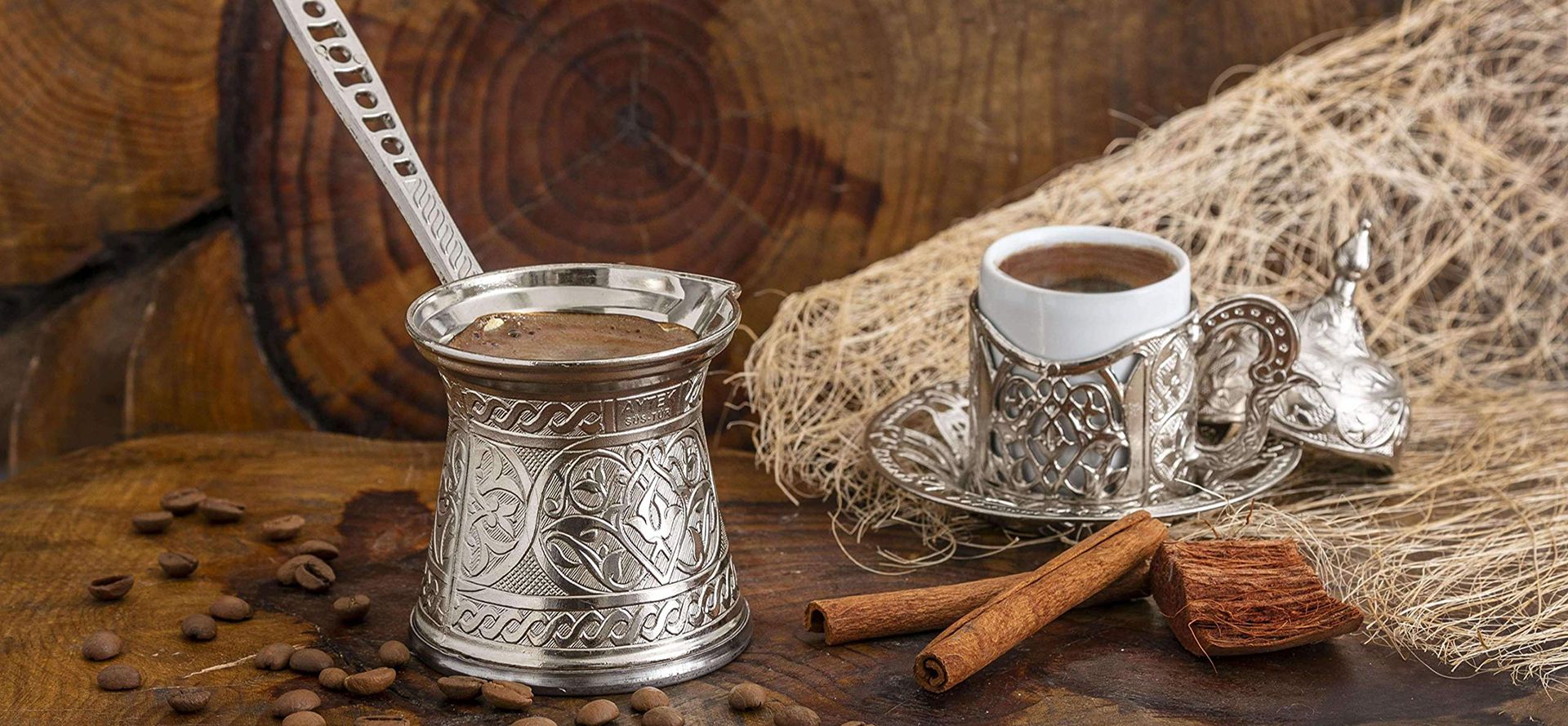 Stainless steel turkish coffee pot with a cup of coffee.