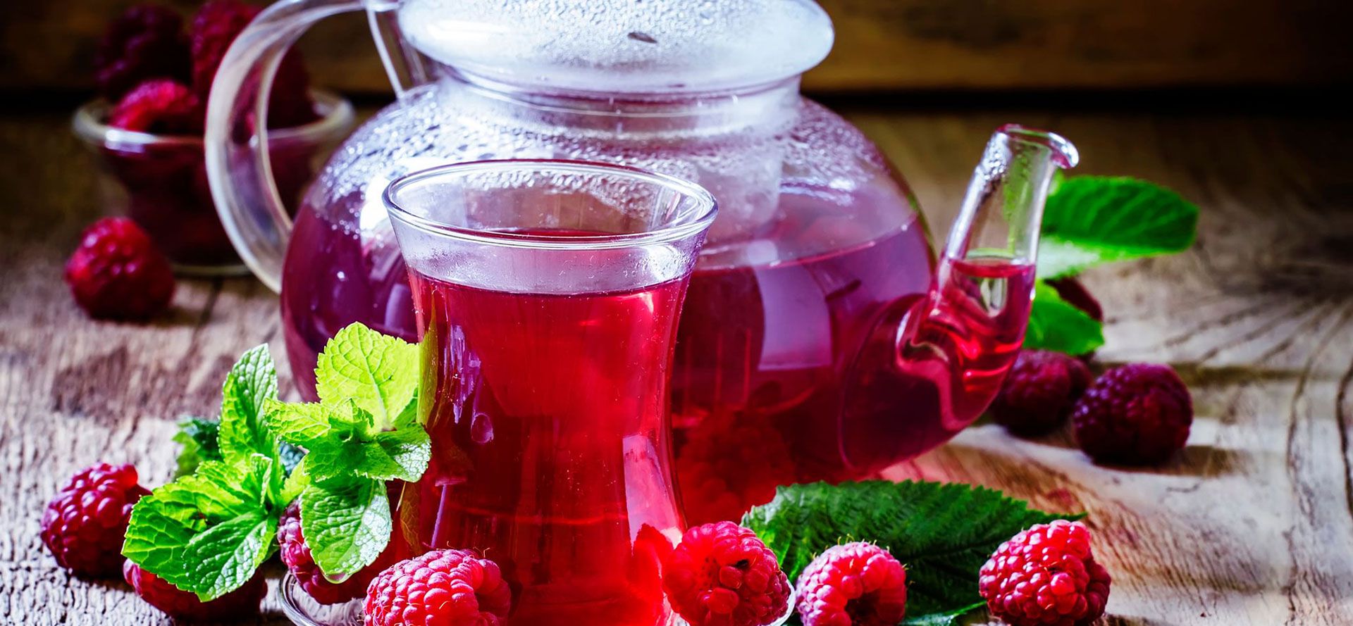 Raspberry tea with kettle on table